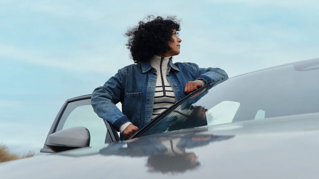 Kvinde står ved en bil