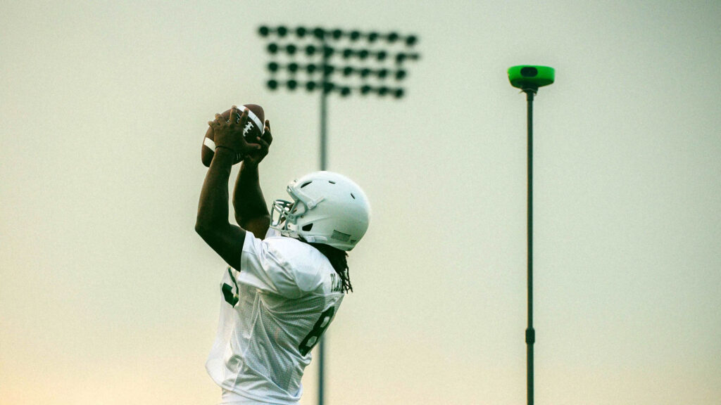 En mand spiller amerikansk fodbold mens Veo optager ham